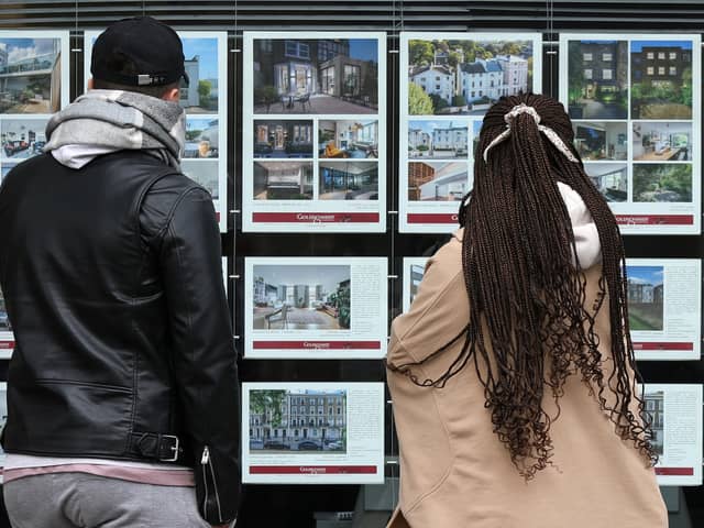 People look at residential properties displayed for sale in the window of an estate agents' in London (Photo: ISABEL INFANTES/AFP via Getty Images)