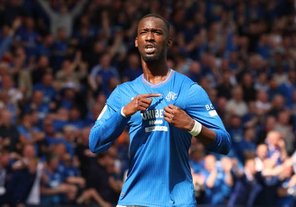 Abdallah Sima of Rangers points to the club's badge