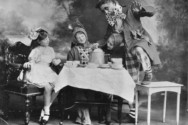 circa 1910:  The Mad Hatter's tea party, a scene from a theatre production of 'Alice In Wonderland'.
