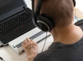 Global Accessibility Awareness Day focuses on digital access and inclusion for people with disabilities or impairments. (Image shows visually impaired person working on computer with assistive technology) 