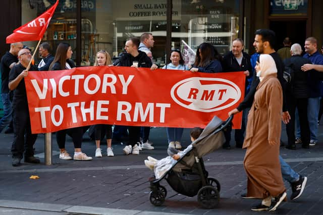 Rail workers stand on a picket line during the RMT strike on 27 July 2022