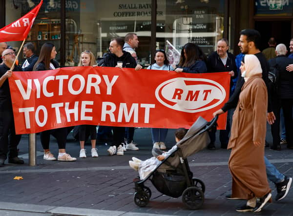 Rail workers stand on a picket line during the RMT strike on 27 July 2022