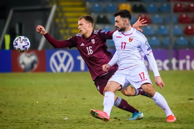 Latvia’s midfielder Alvis Jaunzems (L) and Montenegro’s midfielder Sead Haksabanovic vie for the ball during the FIFA World Cup Qatar 2022 qualification football match in Riga 