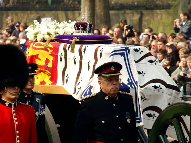 Soldiers accompany a gun carriage holding the coffin bearing the Queen Mother April 5, 2002.