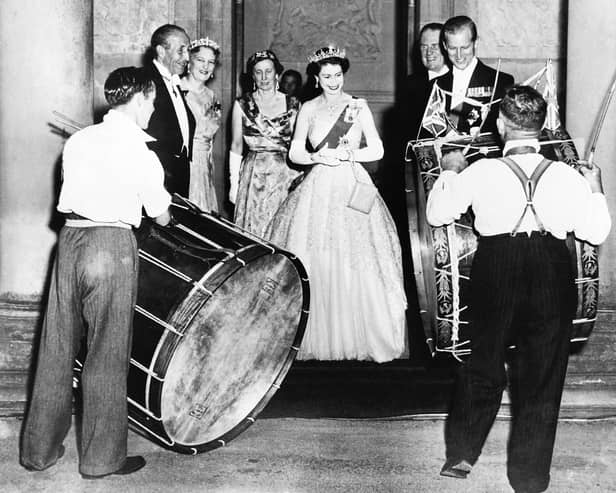 John Warden Brooke, 2nd Viscount Brookeborough (L), Queen Elizabeth II (C) and her husband Prince Philip, Duke of Edinburgh listen to drummers, on July 3, 1953 during their official visit to Northern Ireland.