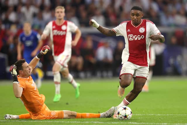 Steven Bergwijn of Ajax runs with the ball past Jon McLaughlin of Rangers to scores his team fourth goal during the UEFA Champions League group A match between AFC Ajax and Rangers