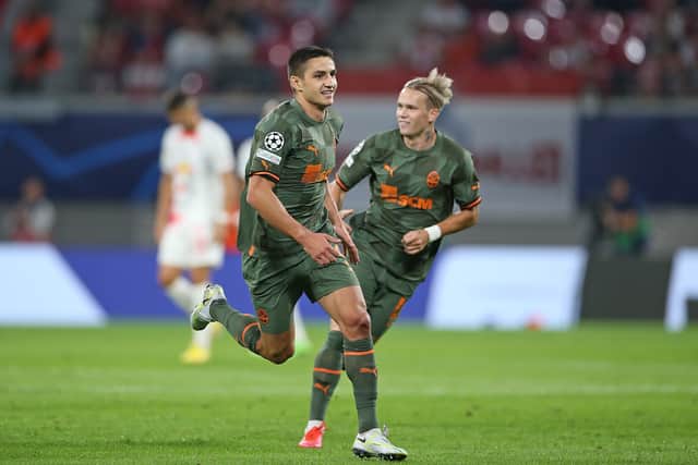 Marian Shved (L) of Shakhtar Donetsk celebrates with teammate Mykhaylo Mudryk (R) after scoring their team's first goal during the UEFA Champions League group F match between RB Leipzig and Shakhtar Donetsk at Red Bull Arena