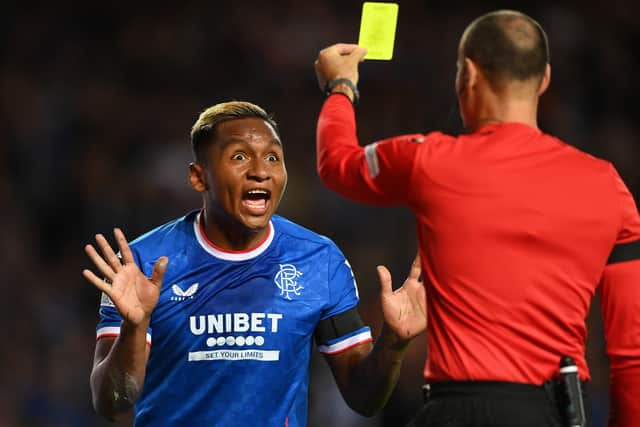 Antonio Mateu Lahoz shows a yellow card to Alfredo Morelos of Rangers