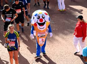 Members of the public finish during the 2021 Virgin Money London Marathon