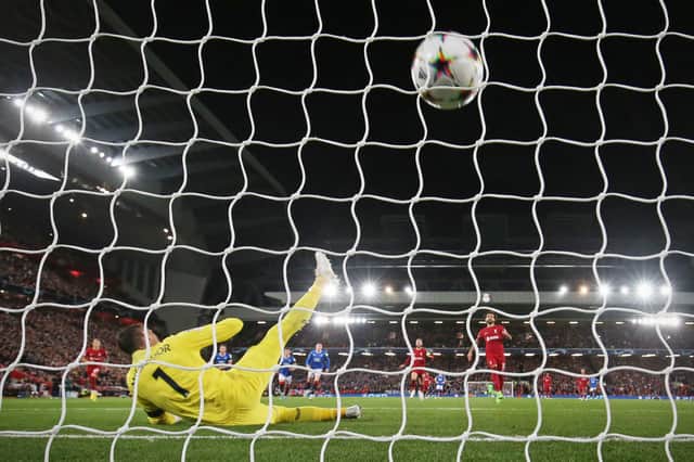 Rangers’ Scottish goalkeeper Allan McGregor (L) dives as Liverpool’s Egyptian striker Mohamed Salah (C) shoots to score from the penalty spot 