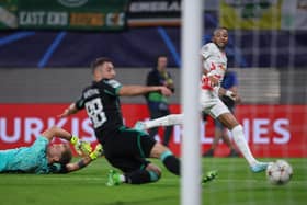 Celtic's English goalkeeper Joe Hart (L) and Celtic's Croatian defender Josip Juranovic fail to stop Leipzig's French midfielder Christopher Nkunku (R) from scoring