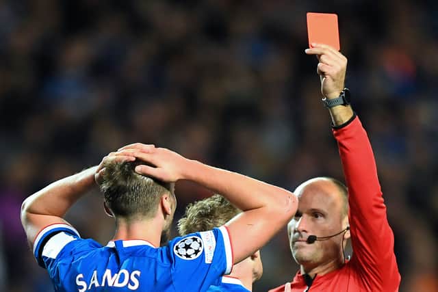 Spanish referee Mateu Lahoz (R) shows a red card to Rangers' US midfielder James Sands (C) during the UEFA Champions League Group A football match between Scotland's Rangers and Italy's Napoli at Ibrox stadium