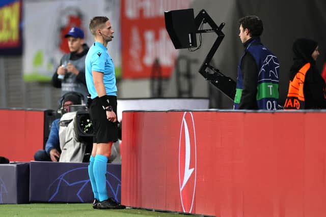 Referee Espen Eskas checks the VAR screen and later disallows a goal for RB Leipzig during the UEFA Champions League Group F match against Celtic at Red Bull Arena