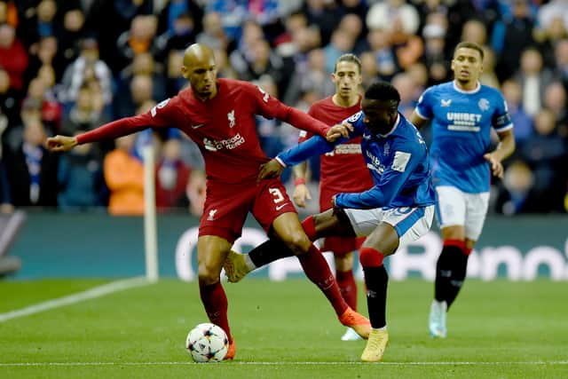 Fabinho of Liverpool (L) holds off Fashion Sakala of Rangers (R)