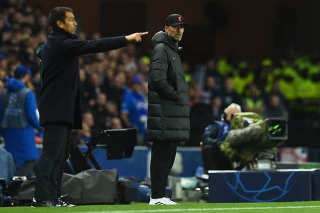 Giovanni Van Bronckhorst issues instructions to his Rangers players as Liverpool boss Jurgen Klopp watches on
