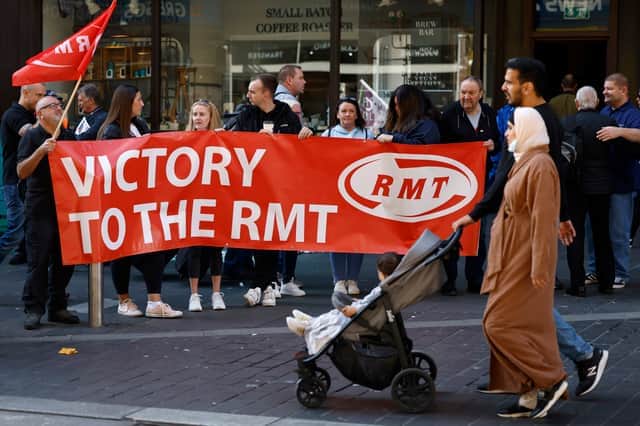 Rail workers stand on a picket line during the RMT strike on 27 July 2022