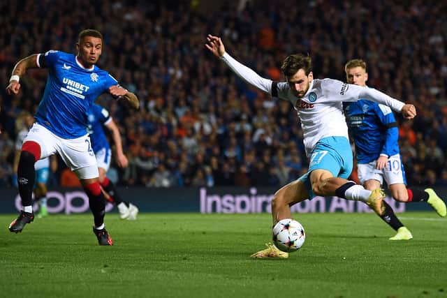 Napoli's Georgian forward Khvicha Kvaratskhelia (2nd R) kick the ball as Rangers' English defender James Tavernier (L) attemps to block it 