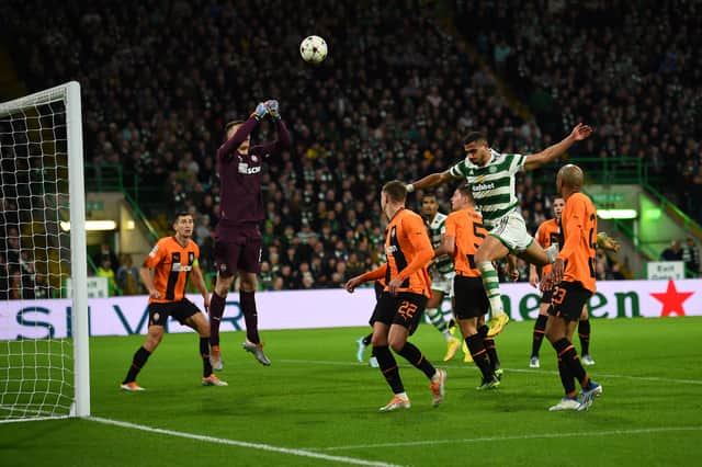 Shakhtar Donetsk's Ukranian goalkeeper Anatoliy Trubin (L) jumps to stop the ball headed by Celtic's Greek striker Giorgos Giakoumakis (2nd R)