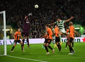 Shakhtar Donetsk's Ukranian goalkeeper Anatoliy Trubin (L) jumps to stop the ball headed by Celtic's Greek striker Giorgos Giakoumakis (2nd R) 