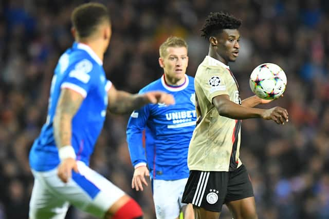 Ajax’s Ghanaian midfielder Mohammed Kudus (R) controls the ball as Steven Davis of Rangers looks on look on