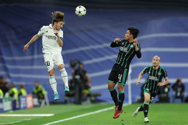 Real Madrid's Croatian midfielder Luka Modric (L) heads the ball next to Celtic's Japanese midfielder Reo Hatate