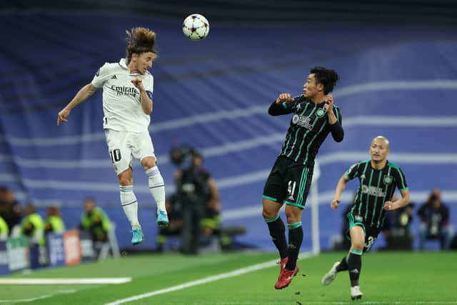 Real Madrid's Croatian midfielder Luka Modric (L) heads the ball next to Celtic's Japanese midfielder Reo Hatate 