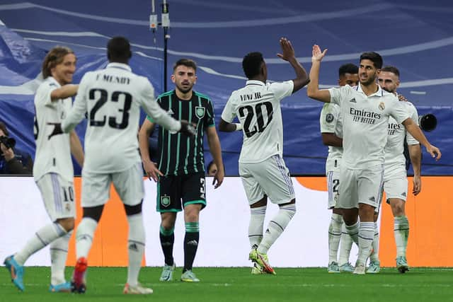 Real Madrid's Spanish midfielder Marco Asensio (R) celebrates with teammates after scoring his team's third goal 