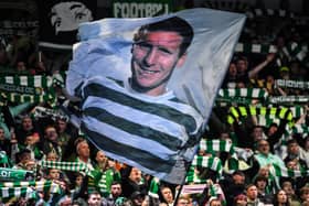 Celtic's fans wave a flag picturing former captain Billy McNeill 