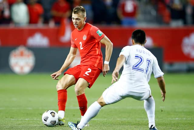 Alistair Johnston of Canada passes the ball as Jonathan Rubio of Honduras defends during a 2022 World Cup qualifier