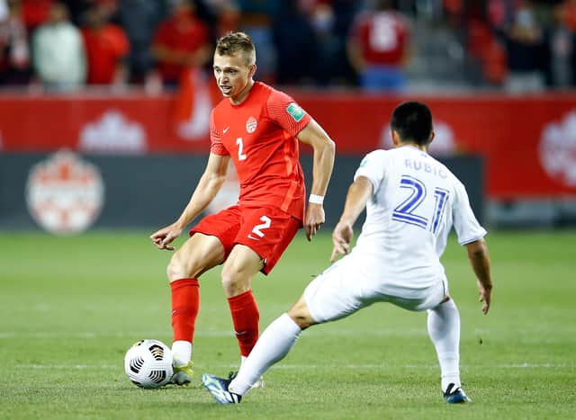 Alistair Johnston of Canada passes the ball as Jonathan Rubio of Honduras defends during a 2022 World Cup qualifier