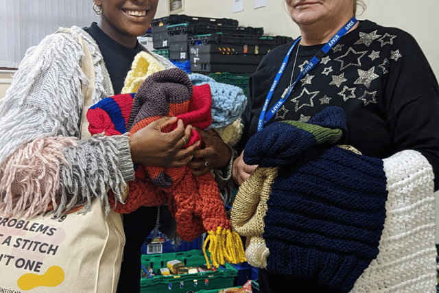 Sew Confident members pose with just some of the winter warmers they’ve knitted for the community.