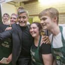 George Clooney poses for a selfie with Social Bite cafe staff
