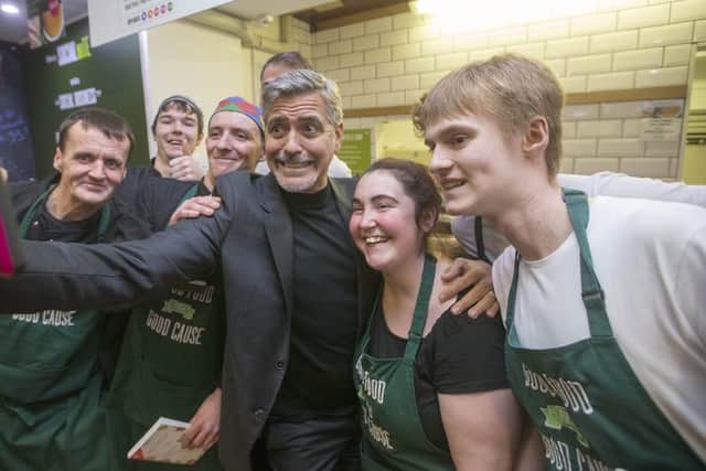 George Clooney poses for a selfie with Social Bite cafe staff