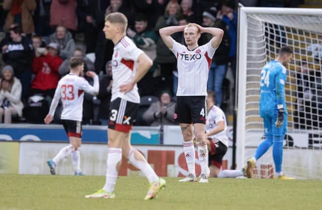 Aberdeen defender Liam Scales cuts a dejected figure as St Mirren celebrate scoring their third goal in stoppage time (Image: SNS Group)