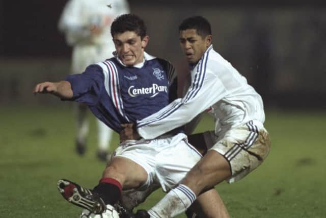 Gordon Petric of Rangers (left) tackles Franck Rabirivony of Auxerre during the champions league match