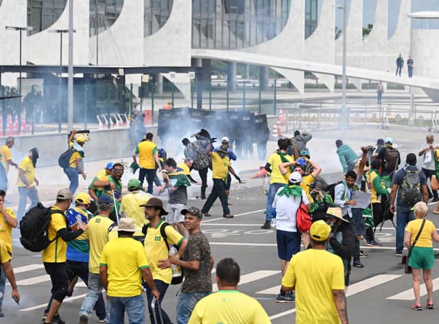Supporters of Brazilian former President Jair Bolsonaro clash with the police during a demonstration outside the Planalto Palace in Brasilia on January 8, 2023. - Brazilian police used tear gas Sunday to repel hundreds of supporters of far-right ex-president Jair Bolsonaro after they stormed onto Congress grounds one week after President Luis Inacio Lula da Silva's inauguration, an AFP photographer witnessed. (Photo by EVARISTO SA / AFP) (Photo by EVARISTO SA/AFP via Getty Images)
