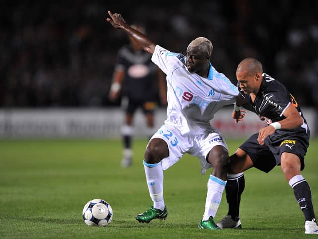 (FILES) In this file photo taken on September 13, 2008 Girondin’s forward Yoan Gouffran (R) fights for the ball with with Marseille’s Cameroonian midfielder Modeste M’ Bami during the French L1 football match between Bordeaux and Olympique de Marseille, at the Chaban Delmas stadium in Bordeaux, southwestern France. - Cameroonian Modeste M’Bami, former midfielder for Paris Saint-Germain and Olympique de Marseille died aged 40 in Le Havre, announces sports agent Frank Belhassen, on January 7, 2023. (Photo by PIERRE ANDRIEU / AFP) (Photo by PIERRE ANDRIEU/AFP via Getty Images)