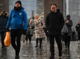 Commuters on their way to work cross London Bridge in central London.