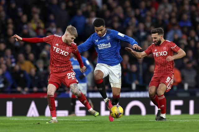  Hayden Coulson and Graeme Shinnie of Aberdeen battle for possession with Malik Tillman of Rangers
