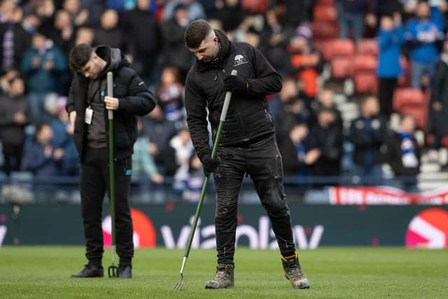 Staff work on the Hampden pitch at half-time on Sunday (Image: SNS Group)