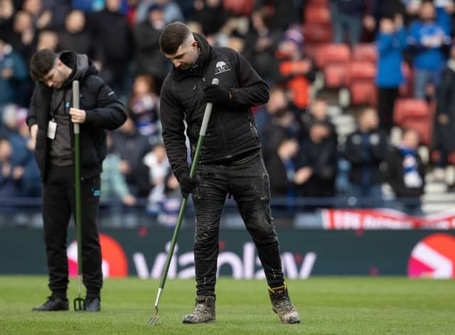 Staff work on the Hampden pitch at half-time on Sunday (Image: SNS Group)