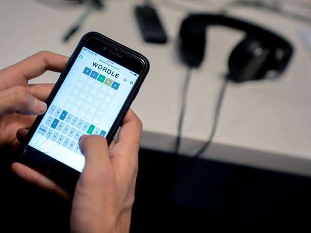 This photo illustration shows a person playing online word game “Wordle” on a mobile phone in Washington, DC on January 11, 2022 (Photo by STEFANI REYNOLDS/AFP via Getty Images)