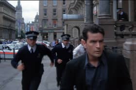 A screengrab from the movie Obit, featuring Charlie Sheen running with Police down St Vincent Place