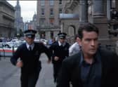 A screengrab from the movie Obit, featuring Charlie Sheen running with Police down St Vincent Place