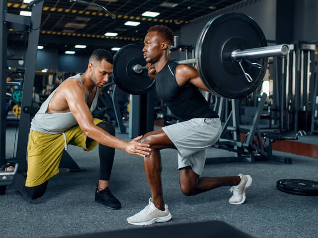 Man with his trainer in gym (Adobe)