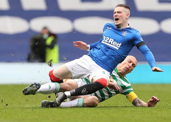 Scott Brown of Celtic fouls Ryan Kent of Rangers and earns a yellow card during a Scottish Cup tie in April 2021