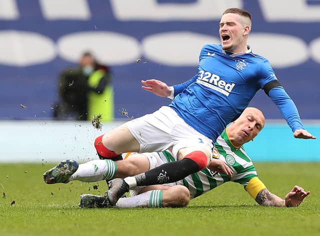 Scott Brown of Celtic fouls Ryan Kent of Rangers and earns a yellow card during a Scottish Cup tie in April 2021