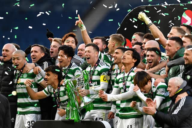 Callum McGregor of Celtic lifts the Viaplay Cup trophy with team mates