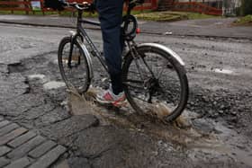 A cyclist rides through a pothole on March 4, 2011 in Glasgow, Scotland. The city’s roads had similar issues with potholes back in 2011 due to one of the coldest winters on record