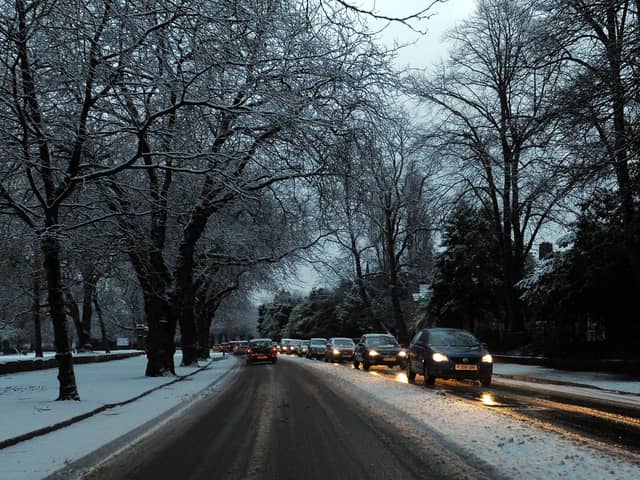 Cars drive on snowy roads in Liverpool.